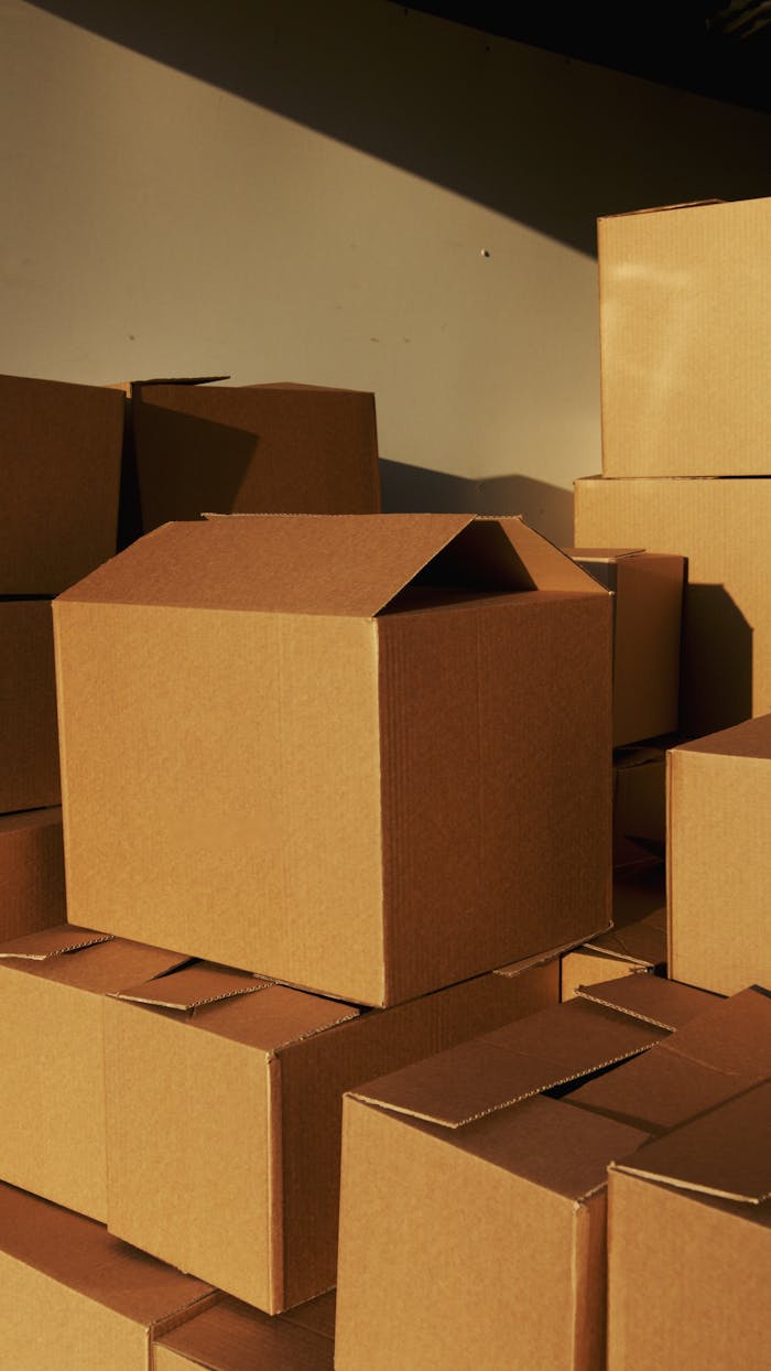 why-choose-us Stacked cardboard boxes ready for shipping or storage in a warehouse setting.
